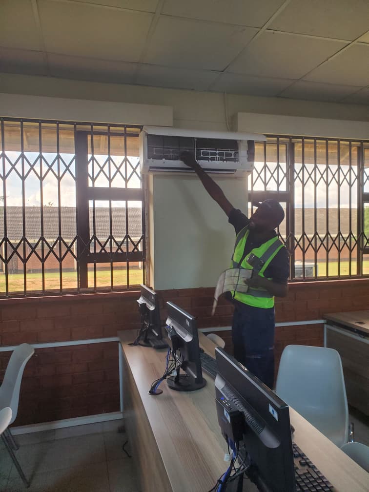 Breeze Empire Tech technician servicing air conditioning in a school computer lab